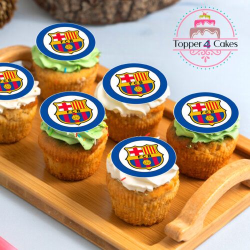 A wooden tray showcases cupcakes adorned with edible Barcelona football club logos, set on a white surface. Alongside them is an Edible Liverpool Cupcake Topper Personalised specially for fans. In the background, the Topper 4 Cakes logo adds a sweet touch to your celebration.
