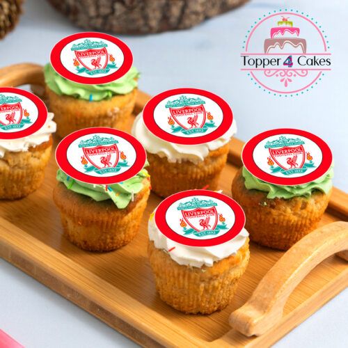A wooden tray of cupcakes is adorned with edible Liverpool cupcake toppers, personalized with a red and white logo. The array of colorful frostings perfectly complements the Edible Liverpool Cupcake Topper Personalised brand in the background.