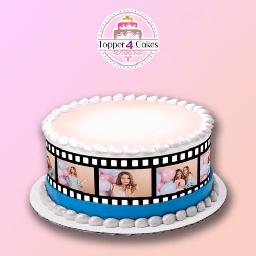 A round cake with a pink and white gradient frosting is decorated using the Edible Film Photo Ribbon, showcasing images of two girls holding balloons. The top is smooth, and a logo saying "Topper 4 Cakes" is elegantly placed at the center.