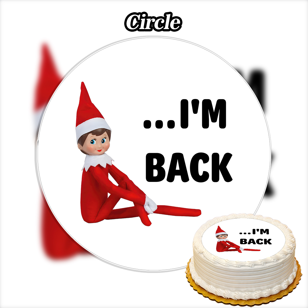 A round cake with white frosting is decorated with the Edible The Elf on the Shelf Cake Topper (Copy) and "...IM BACK" in bold black letters. The elf figure sits on top with arms and legs extended.